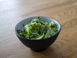 A Bowl Of Broccoli Sitting On Top Of A Wooden Table